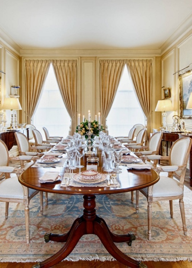 طاولة طعام كبيرة تعلوها إنارة كريستال تتدلى من السقف بشكل مميز