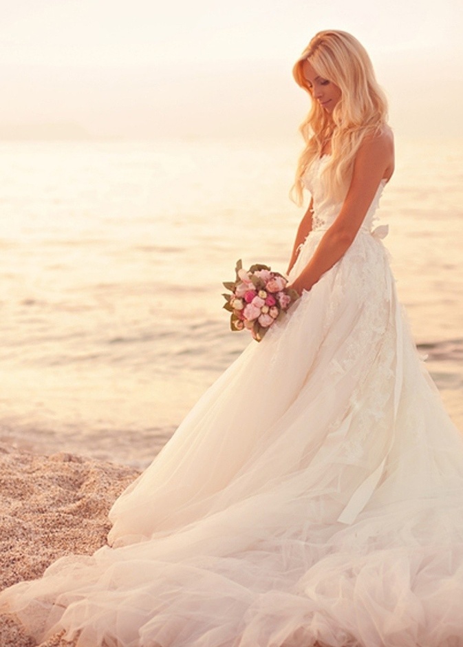 العروس في حفل الزفاف الشاطئي يغلب على إطلالتها البساطة والجمال