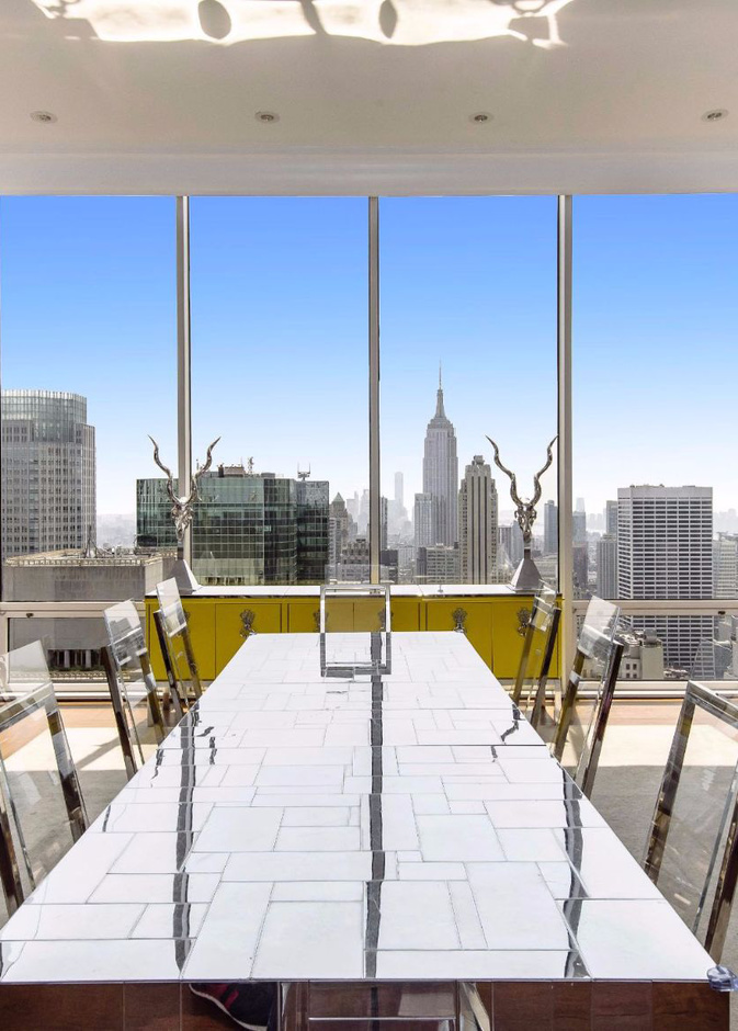 طاولة الطعام المميزة بالسطح العاكس و الكراسي الشفافة المحمولة على هيكل من الحديد  