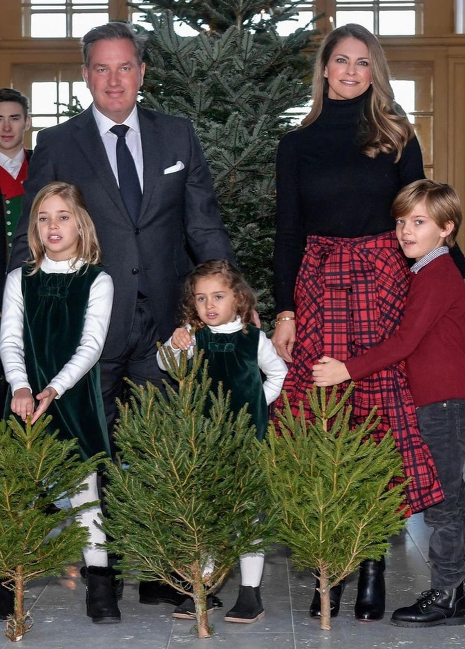 إختارت الكنزة السوداء ذات ياقة دائرية عالية مع تنورة ميدي باللون الأحمر مزيّنة بنقشة الترتان