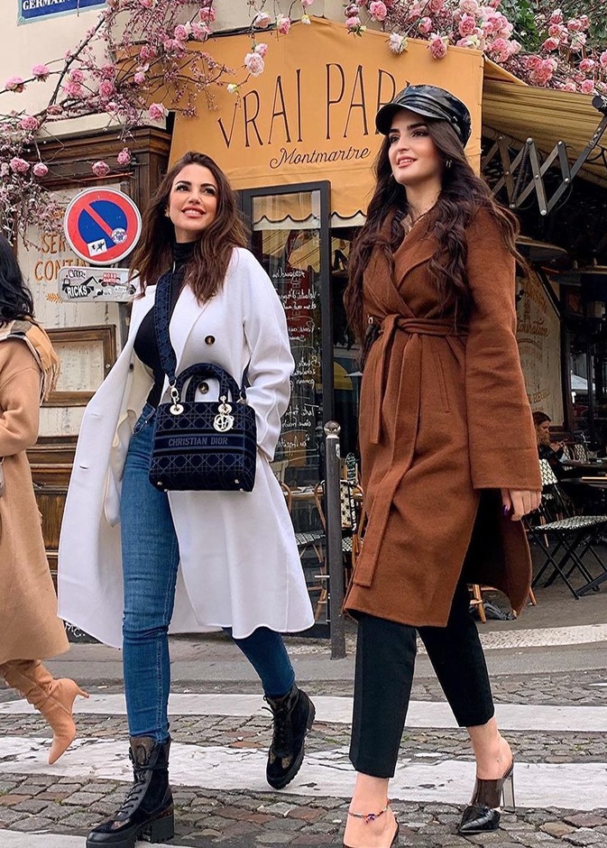 نسّقت الكنزة السوداء بياقة عالية مع البنطلون الدنيم وأكملت اللوك بمعطف أبيض