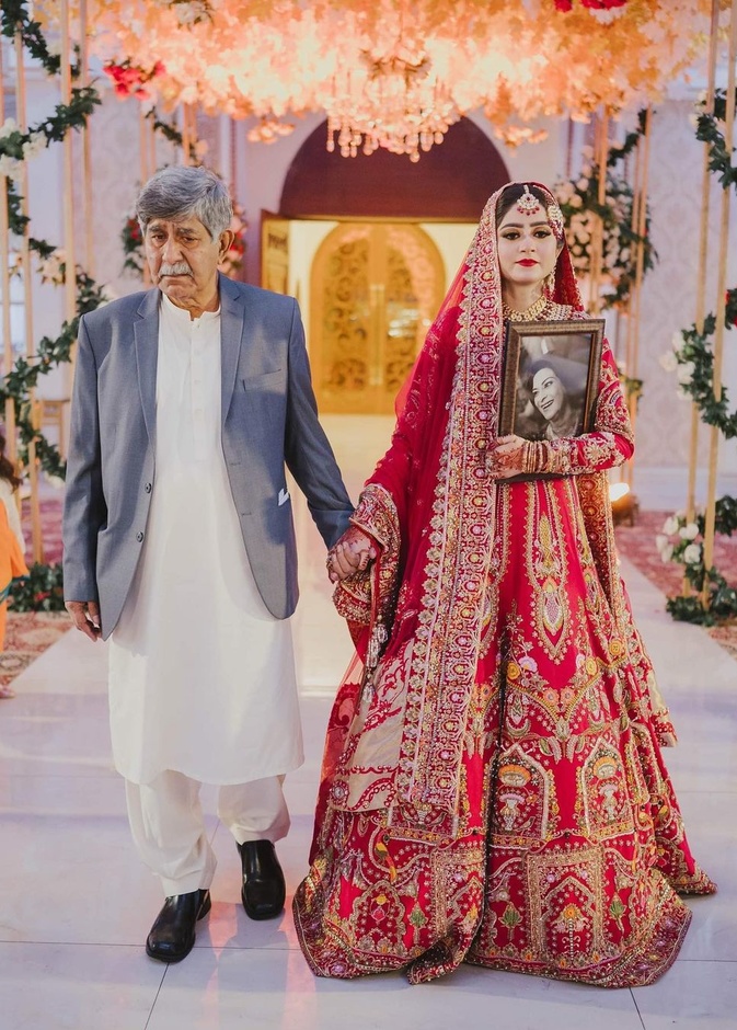 عروس تحمل صورة والدتها الراحلة في حفل زفافها