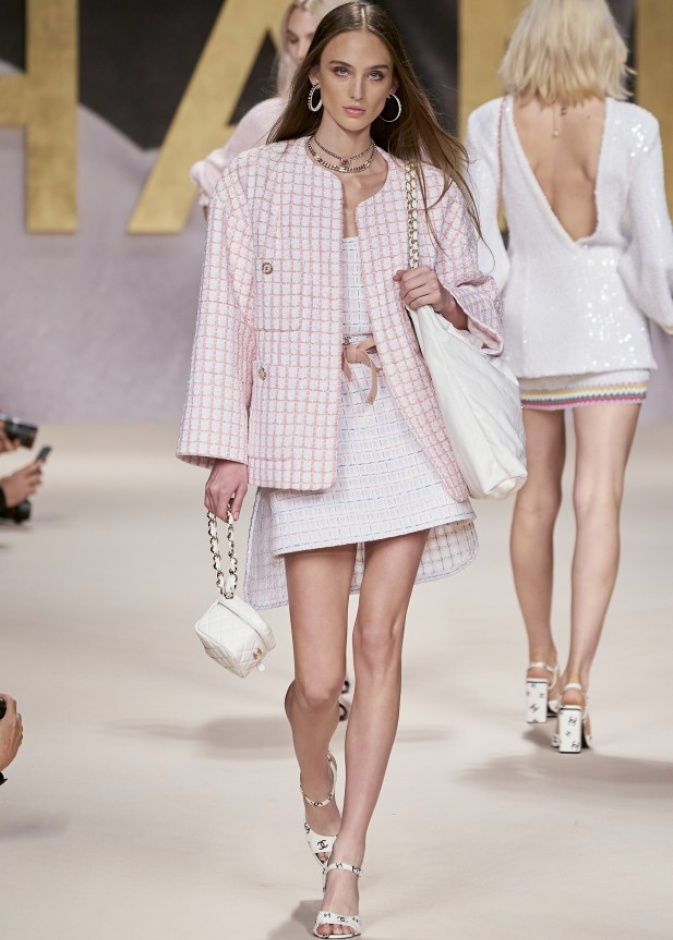 CHANEL نسّقت التنورة القصيرة باللون الأبيض مع الجاكيت الطويلة بنقشة الـGingham