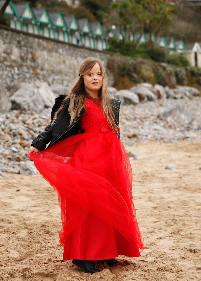 نسقت بيث الفستان السهرة الأحمر مع الجاكيت الجلد