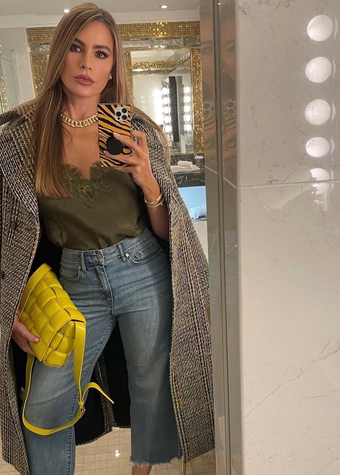 تألقت صوفيا بالبنطلون الدنيم مع التوب الستان والمعطف التويد الأنيق وبرزت حقيبة Bottega Veneta باللون الأصفر