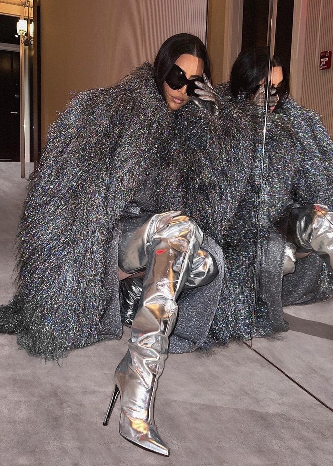 تألقت كيم بالمعطف الفضي نسقت معه فستان رمادي فاتح وجزمة ميتاليكية