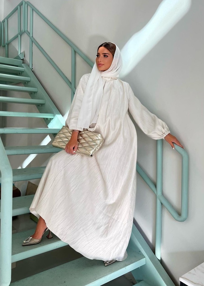 نسقت فاطمة حسام العباية من تصميم Zeina Zain مع حقيبة يد من Saint Laurent وحذاء فضيّ من AMINA MUADDI