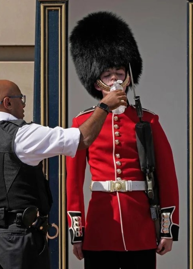 أحد حراس القصر الملكي البريطاني يتلقى شربة ماء بسبب موجة الحر الشديد