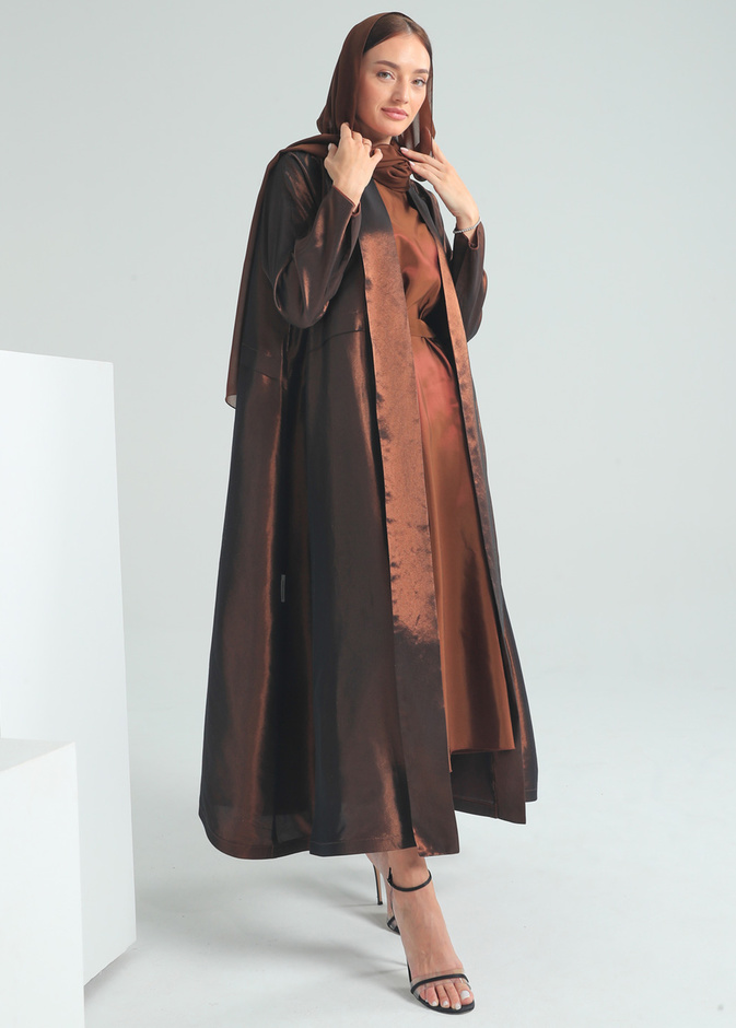 البني الميتاليك واللمّاع بتصميم عباية راقية بقصّة بسيطة من By Budoor