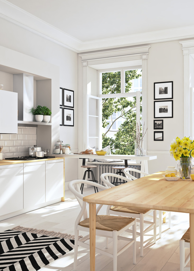 مطبخ أبيض اللون مؤثث بطاولة طعام خشبية وسجادة أنيقة منقوشة بالأبيض والأسود