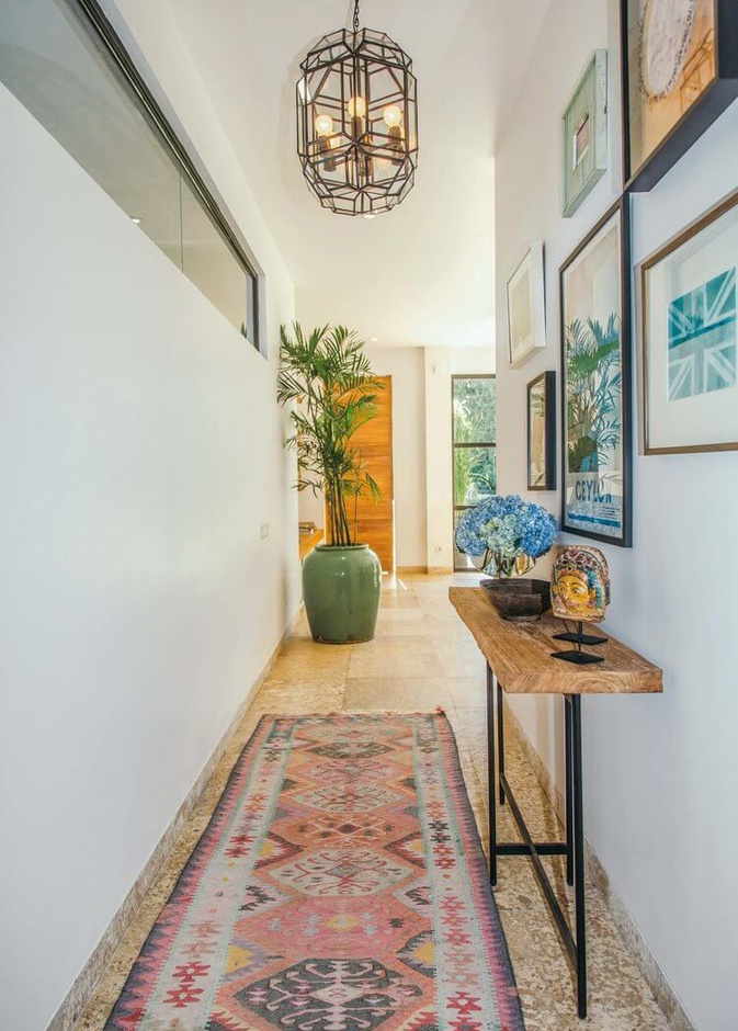 طاولة خشبية وبضعة لوحات تجعل الممر يضج بالحياة