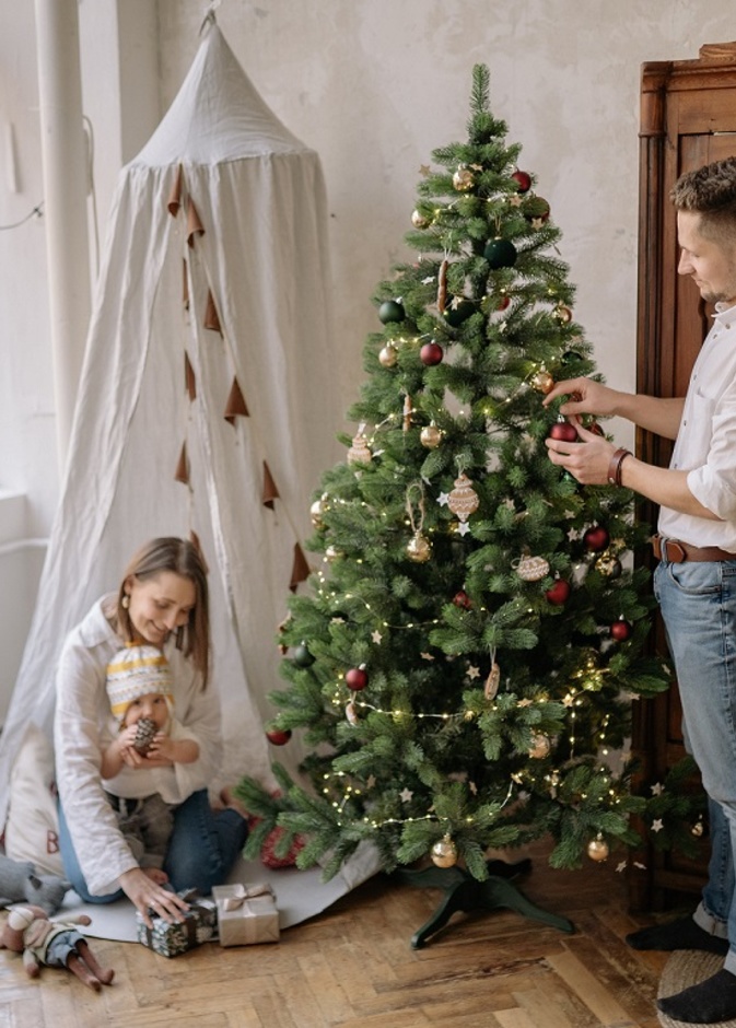 أسرة تقوم بتزيين شجرة عيد الميلاد