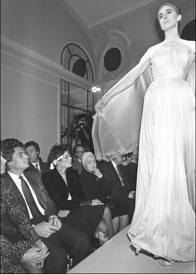 التقطت الصورة في 24 مارس 1985 في باريس لعارضة أزياء أثناء عرض مجموعة الملابس الجاهزة لخريف وشتاء، تحت أنظار المصممة الفرنسية مدام غراي (في الوسط)، في متجرها الواقع في شارع لا بيه في باريس. الصورة من موقع AFP