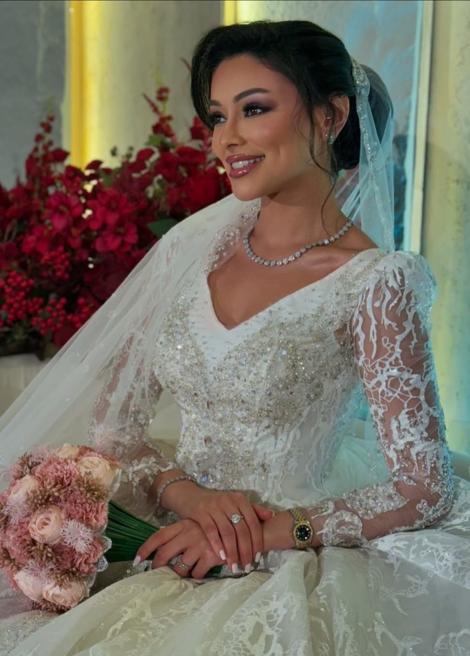 شوق الهادي أول عروس في مسلسلات رمضان 2025..كيف بدت إطلالتها؟  عندليب دندش الإطلالات الأنيقة التي تتميز بها الفنانة الكويتية شوق الهادي إنعكست على رقي إختيارها في إطلالتها العرائسية في المسلسل الرمضاني لعام 2025 أبو البنات، إذ توجهت لاختيار فستان زفاف بموضة القصات المنفوشة ذات التنورة الضخمة والقماش المطرز بالترتر على عكس فستان زفافها في مسلسل أمينة حاف الذي عُرض في رمضان 2021 والذي اعتمد على قماش الساتان وجاء بتفاصيل جداً بسيطة وناعمة باستثناء اليدين التي تم إدخال حركة إليهما على هيئة خيوط لامعة تربط أسفل ا