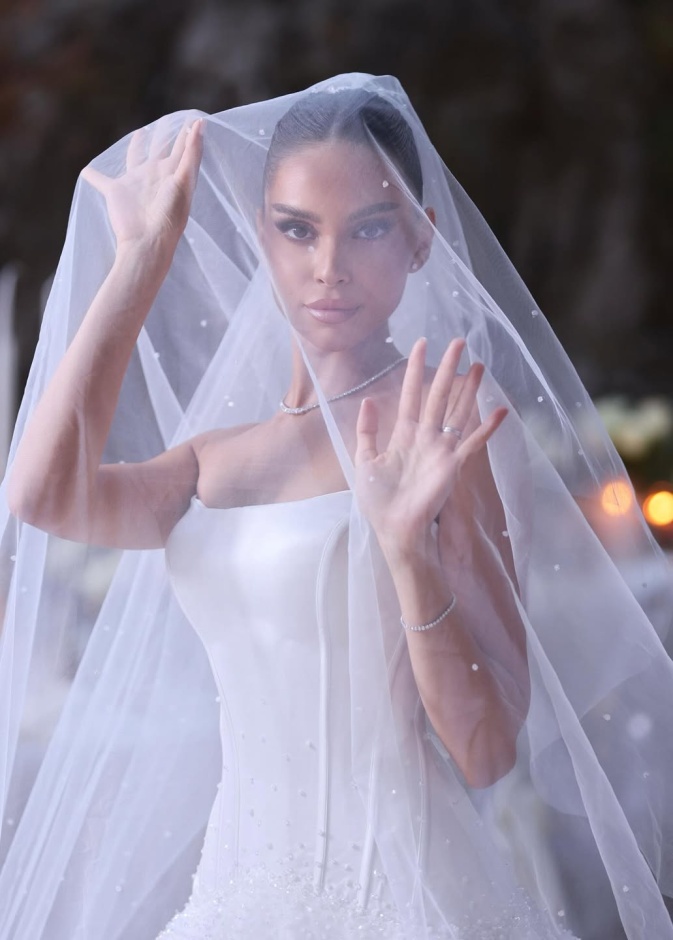 طرحة مزينة باللؤلؤ مع تسريحة شعر مرفوع وهي من تصميم m.rdesign