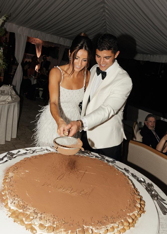 عروسان يقومان بتزيين الكيك مباشرة ليلة الزفاف أمام الضيوف