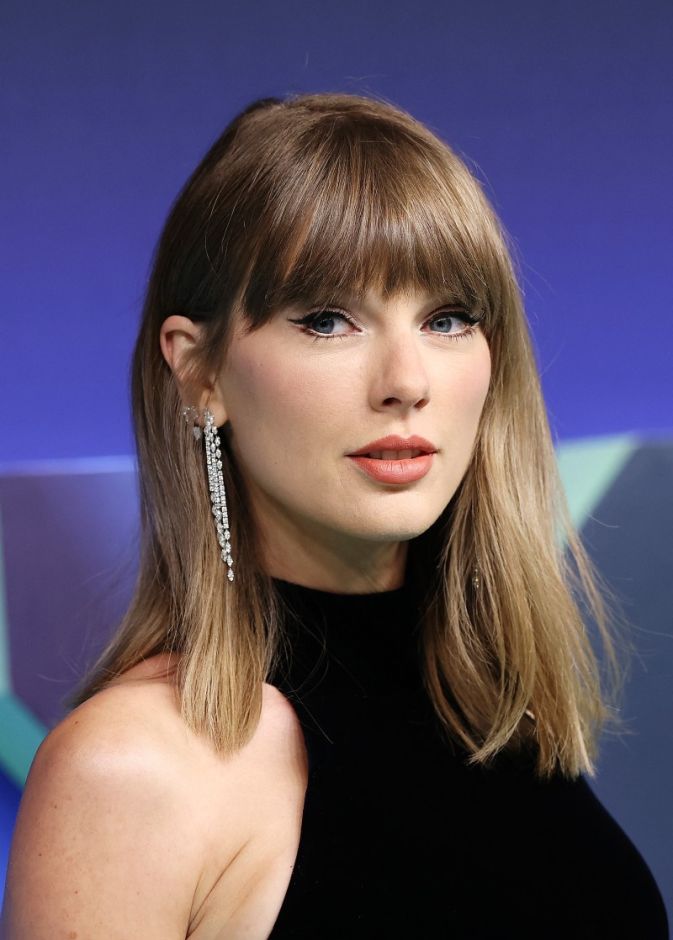 إطلالة Taylor Swift برسمات المكياج البني البراق مع أحمر الشفاه المشمشي