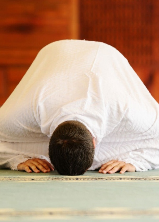 بالفيديو: طفل يتعلق برقبة أبيه في الصلاة