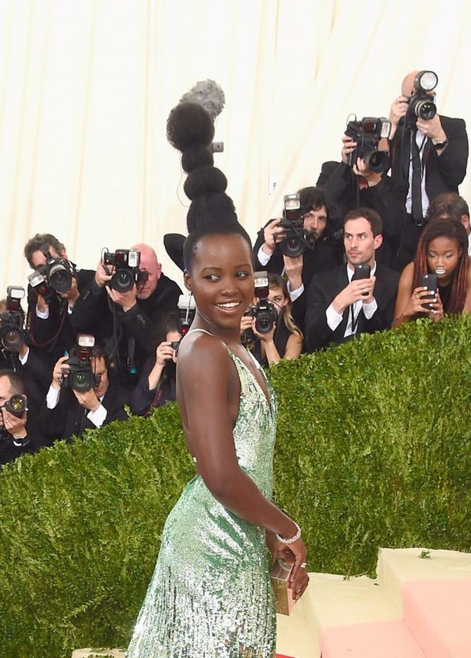 لوبيتا نيونغ تتحدى طول المايكرفون بتسريحتها الغريبة خلال حفل مت جالا في نيويورك أمس