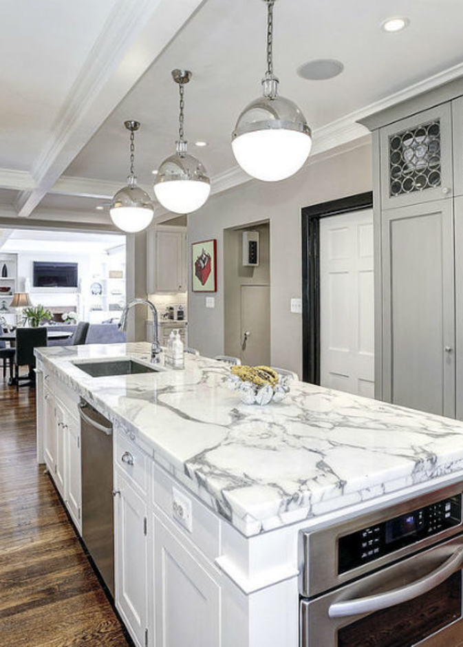 المطبخ ذو التصميم الابيض والطاولة (الجزيرة)