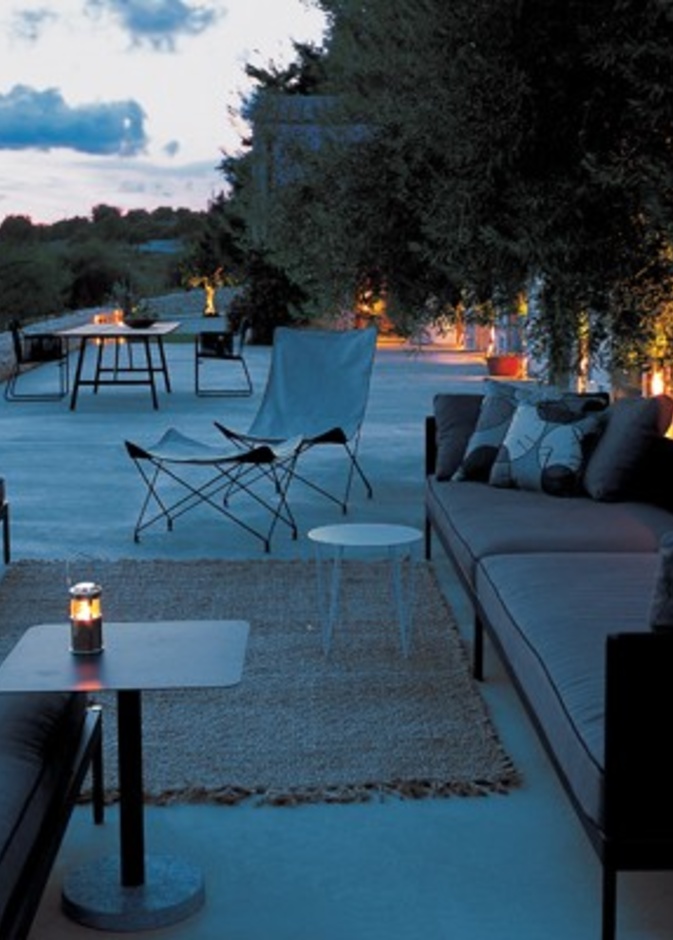 من تصميم Gordon Guillaumier، اخترنا لك جلسة خارجية مودرن بألوان داكنة لجلسة مسائية خاؤجية دافئة.