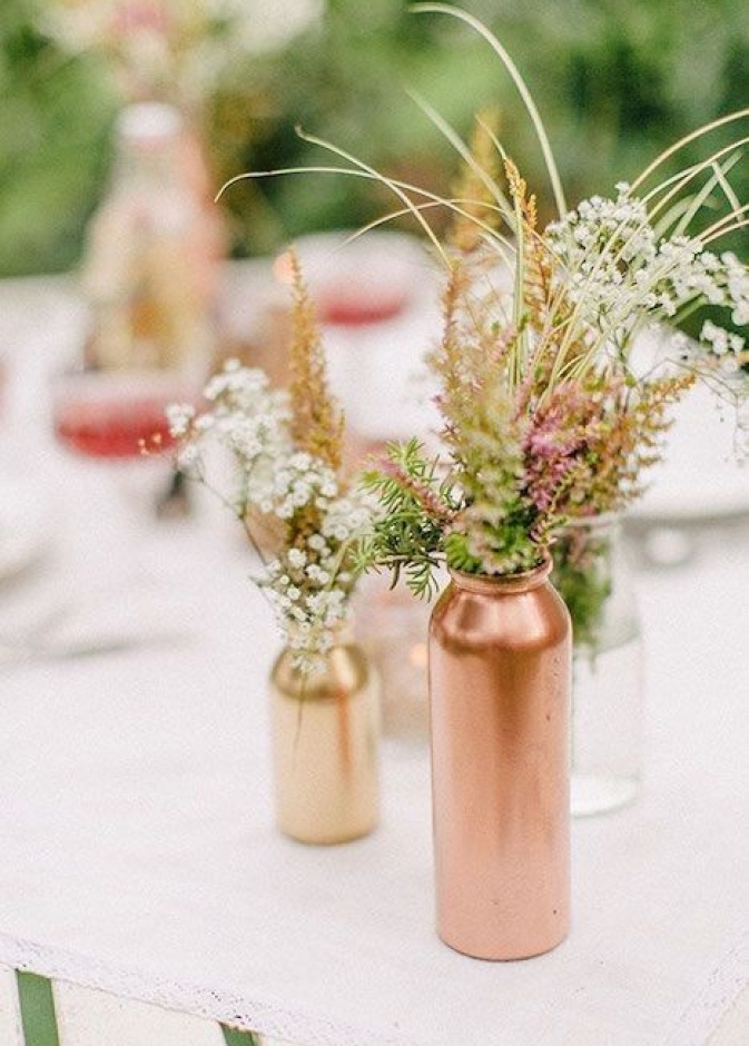 تزيين طاولة الزفاف بالقناني البرونزية.