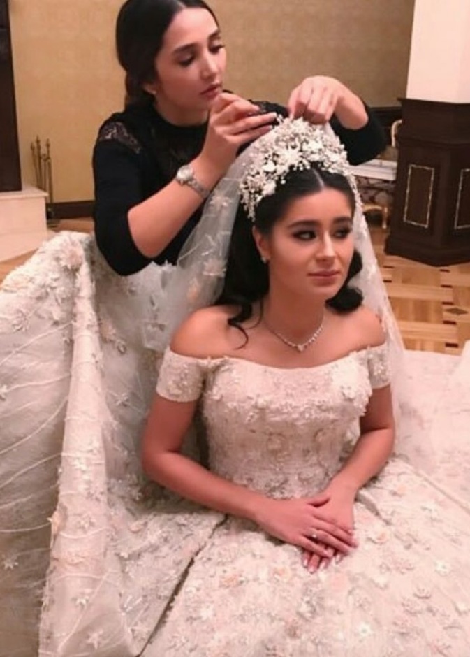 نسقت العروس الروسية طرحة طويلة فخمة مع فستان الزفاف