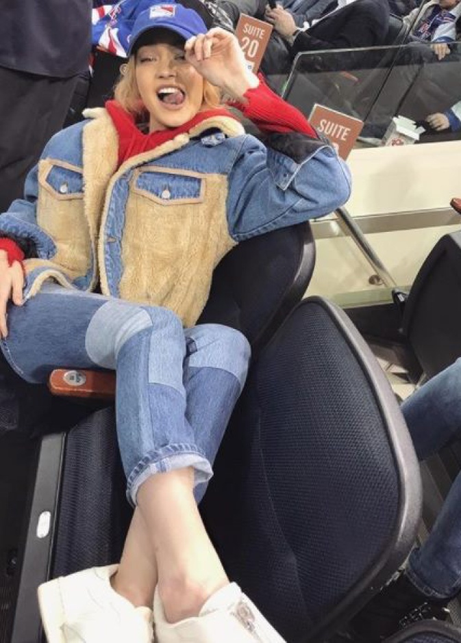 جيجي حديد تتخذ وضعية رشيقة أثناء تشجيعها لفريق نيويورك رينجرز في مباراة هوكي