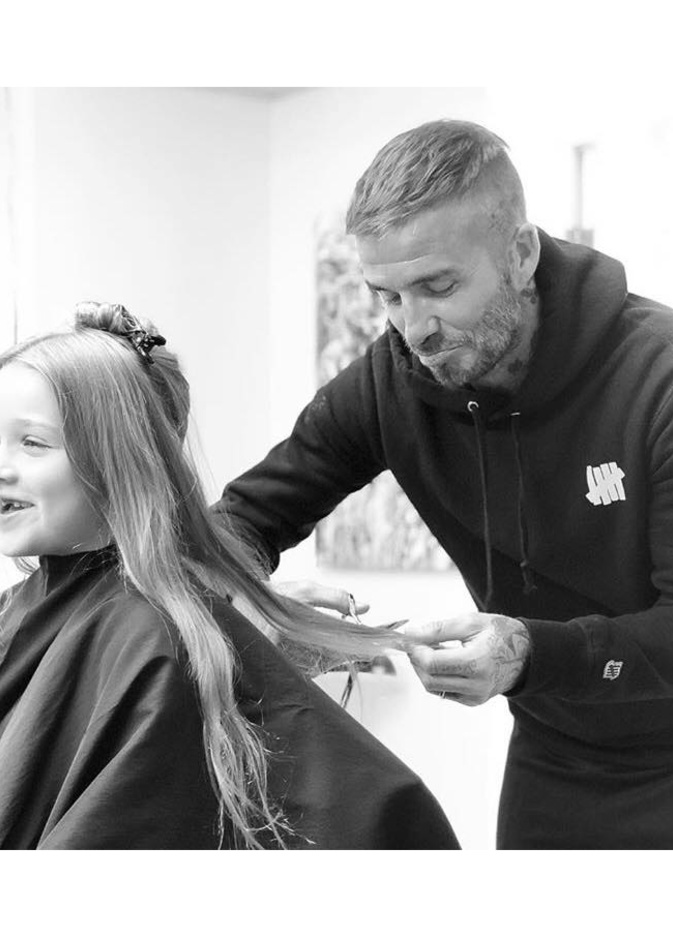 يبدو ديفيد بيكهام متأثرا وهو يقص الخصلات الطويلة لشعر ابنته هاربر