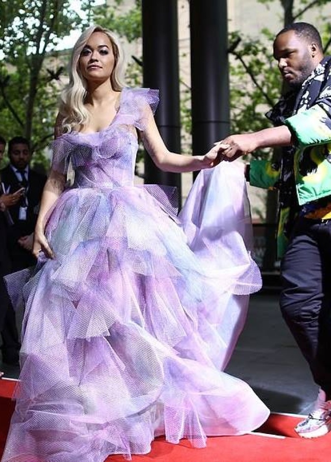 ريتا أورا تتلقى المساعدة من أحد المصورين لدى حضورها لحفل ARIA Award في سيدني