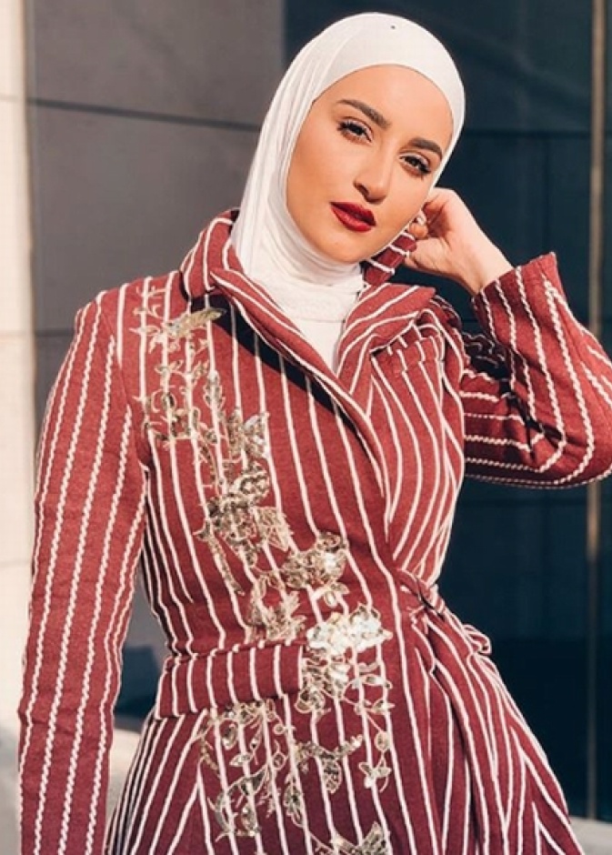 اختارت دلال الدوب بليزر أسود أنيق مع حزام ونسّقته مع حجاب أبيض مزيّن بلمسات ناعمة