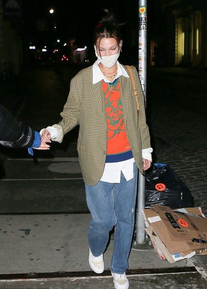 نسّقت قميصاً أبيض مع كنزة برتقالية وفوقها بلايزر بنقشة الـ gingham