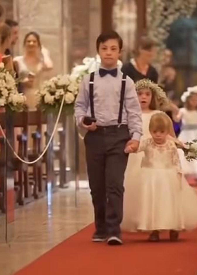 الاطفال متجهين نحو العروسين يتقدمهم أكبرهم و هو يحمل خاتم الزواج