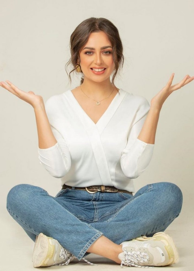 نسّقي البنطلون الدنيم بأسلوب النجمة هبة مجدي مع التوب الأبيض بقصة الـV neck