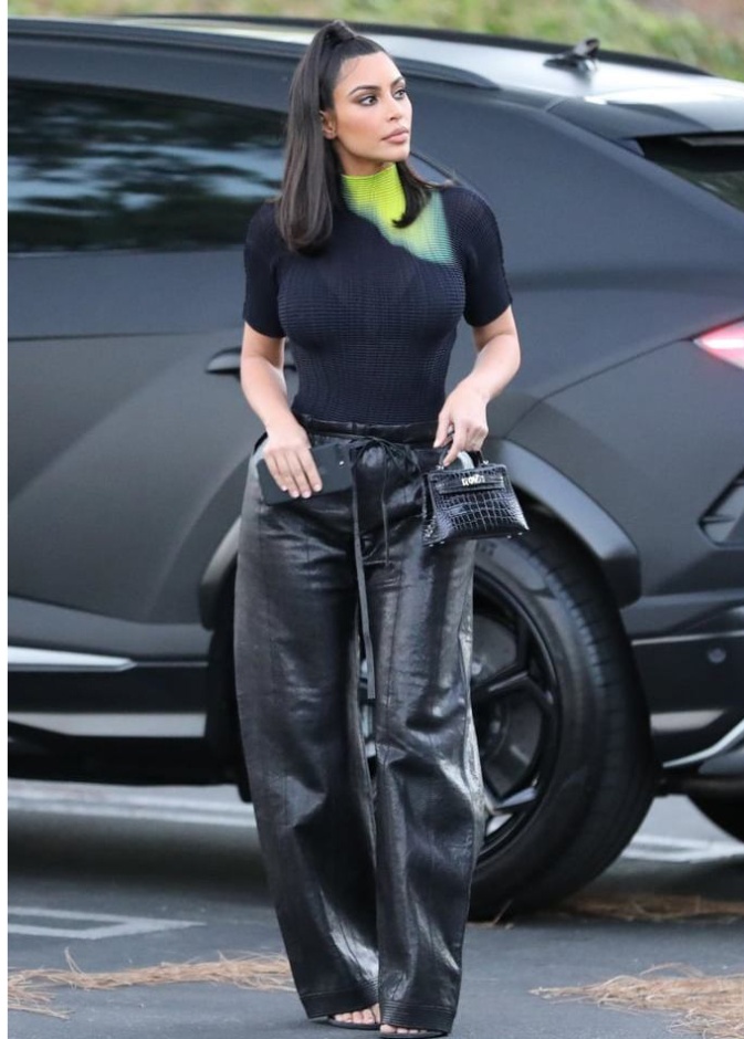 تنسيق السروال الجلد الأسود بقصة الأرجل الواسعة مع توب أسود بنقشة التاي داي