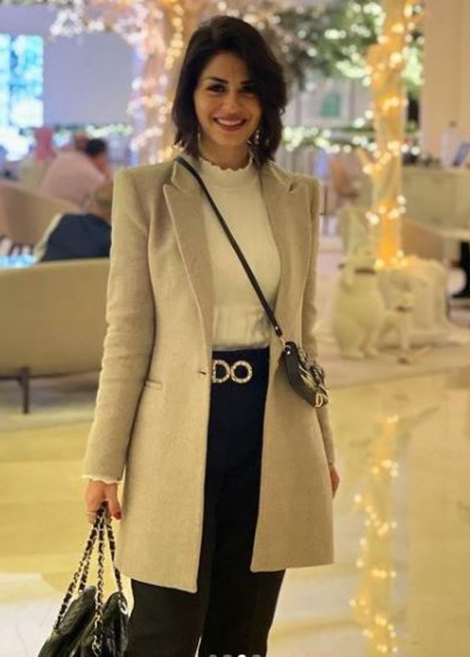 إختاري البنطلون الأسود مع التوب الأبيض بالياقة العالية وأكملي اللوك بمعطف أنيق