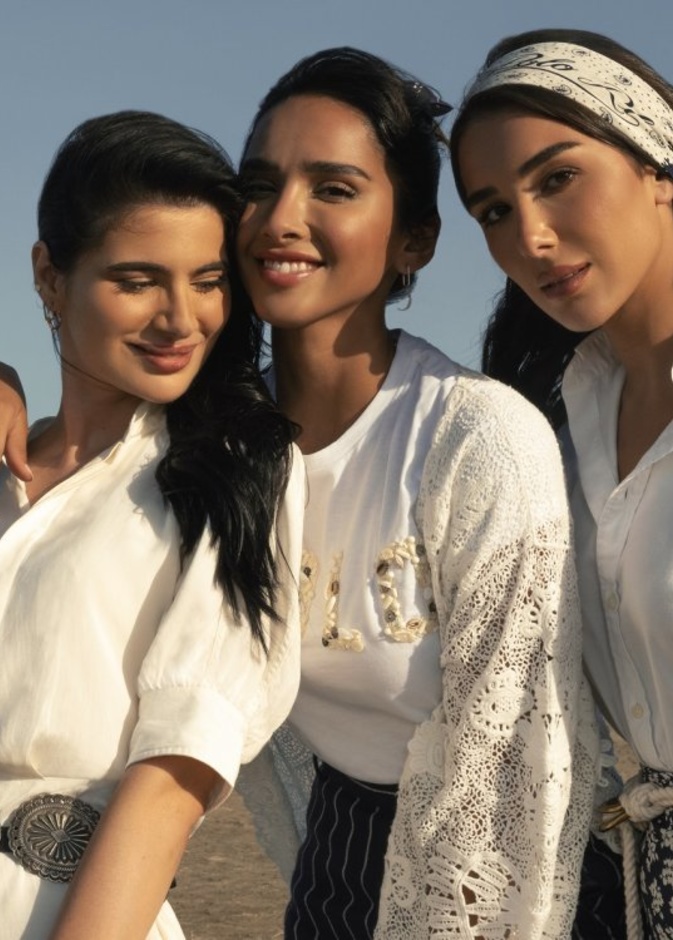 اختارت شينا فستان ميدي تويل من الحرير الأبيض مع حزام مزخرف وحقيبة من القطن سميكة