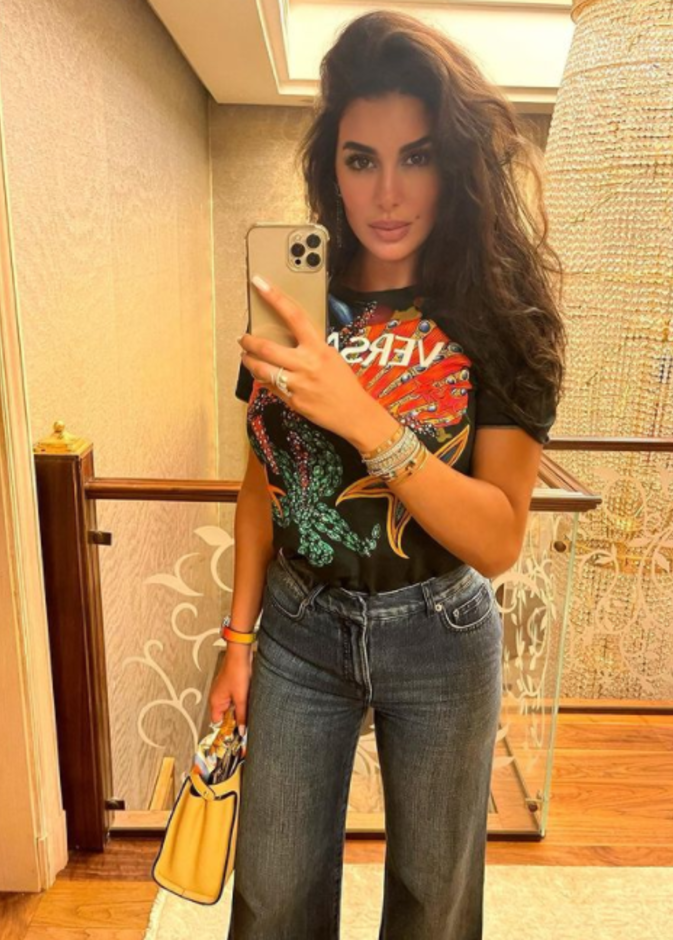 نسّقت تيشيرت من ماركة Versace مع البنطلون الدنيم بقصة الأرجل الواسعة