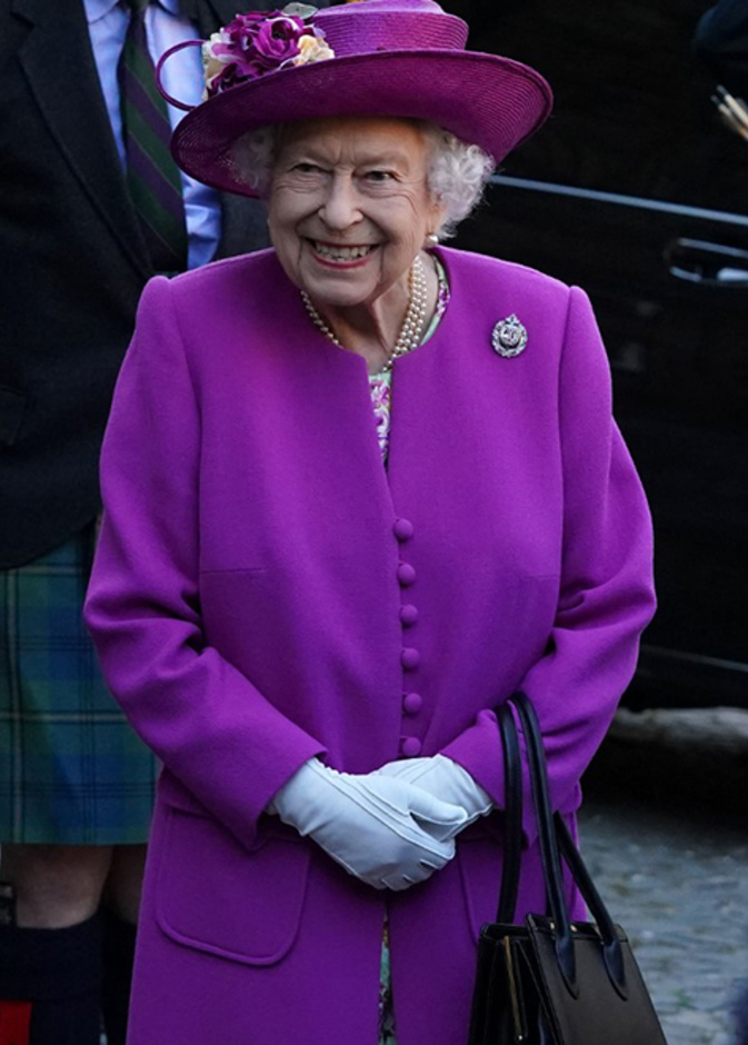 اطلالة الملكة اليزابيث بالمعطف البنفسجي والفستان المورد الصورة من AFP