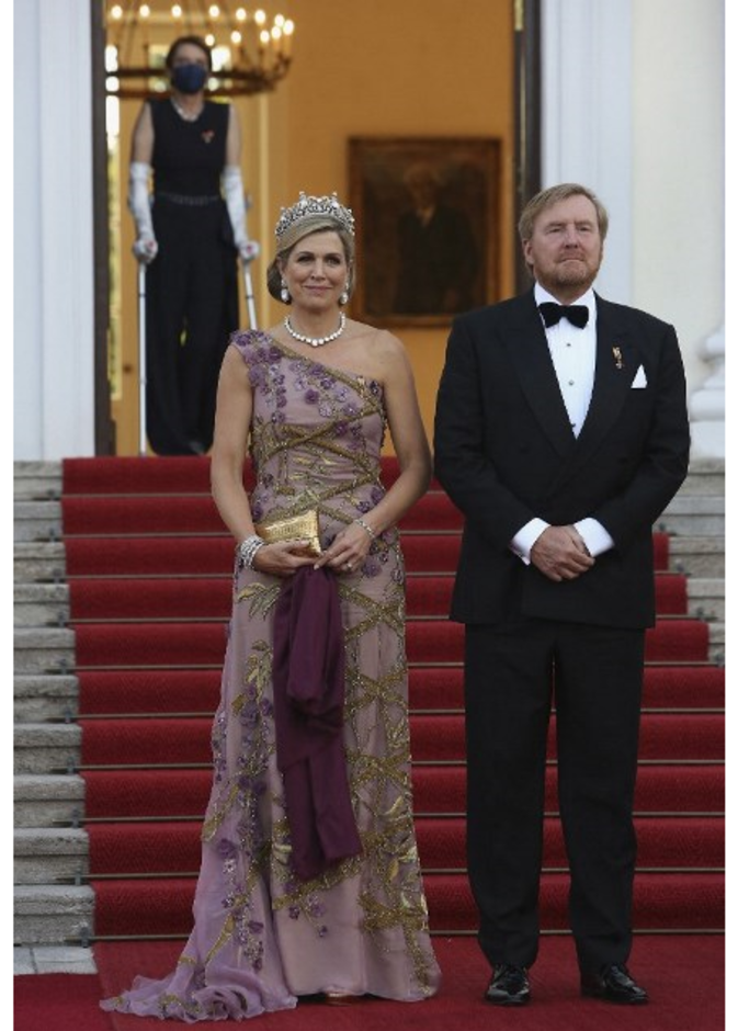 أكملت اللوك بالوشاح باللون البنفسجي الداكن والحقيبة الذهبية