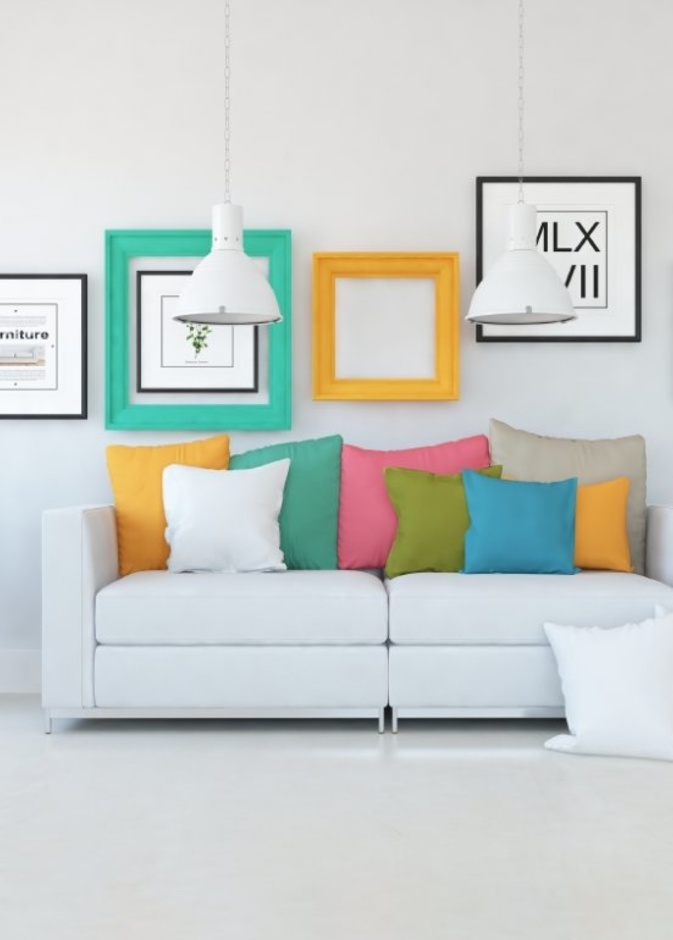 الوسائد الملونة تزين الكنب بلونه الأبيض البسيط