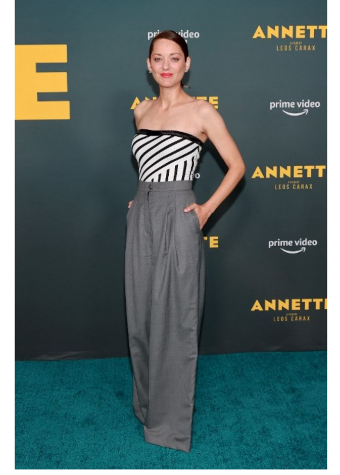 ماريون كوتيارد بإطلالة من دار CHANEL تألفت من البنطلون الرمادي الواسع والتوب بنقشة التقليمات