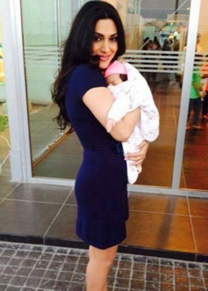 مايا نصري تحمل طفلها