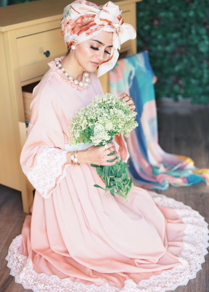 اطلالة غادة عثمان الأنثوية والجذابة بالفستان الزهري الفاتح مع لمسات من الدانتيل والتوربان الملون