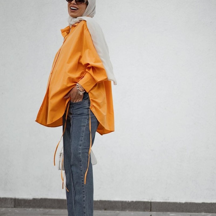 القميص الأورانج بالقصّة العريضة مع الجينز بإطلالة شبابية للحوامل بأسلوب سمر شاكر