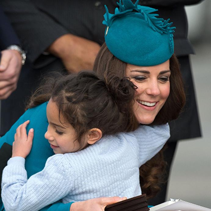 كيت ميدلتون (Kate Middleton) تعانق فتاة صغيرة في مطار دنيدن وكان ذلك خلال زيارة رسمية لها لنيوزيلاندا في عام 2014.