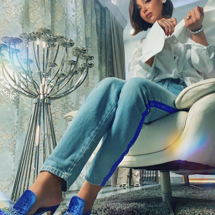 سحرتنا اطلالات بسمة بوسيل بموضة بنطلون الجينز المستقيم والفاتح الذي اختارته بكثير من التميز مع الباند النيلي البارز على الجوانب. واللافت أنها نسّقته مع القميص البيضاء الفضفاضة الى جانب صيحة المول النيلية بالقماش المخملي وحبيبات الستراس الفضية.