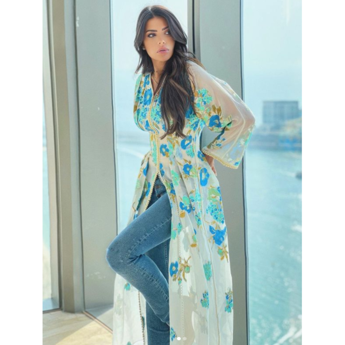 نسقي على طريقة العنود البدر القفطان الأبيض المزيّن بالنقشات مع البنطلون الدنيم الضيق للوك عصريّ