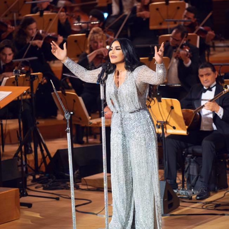 نسقت أحلام معطف مزين بالورود مع حزام جلدي على الخصر ونظارات شمسية كبيرة