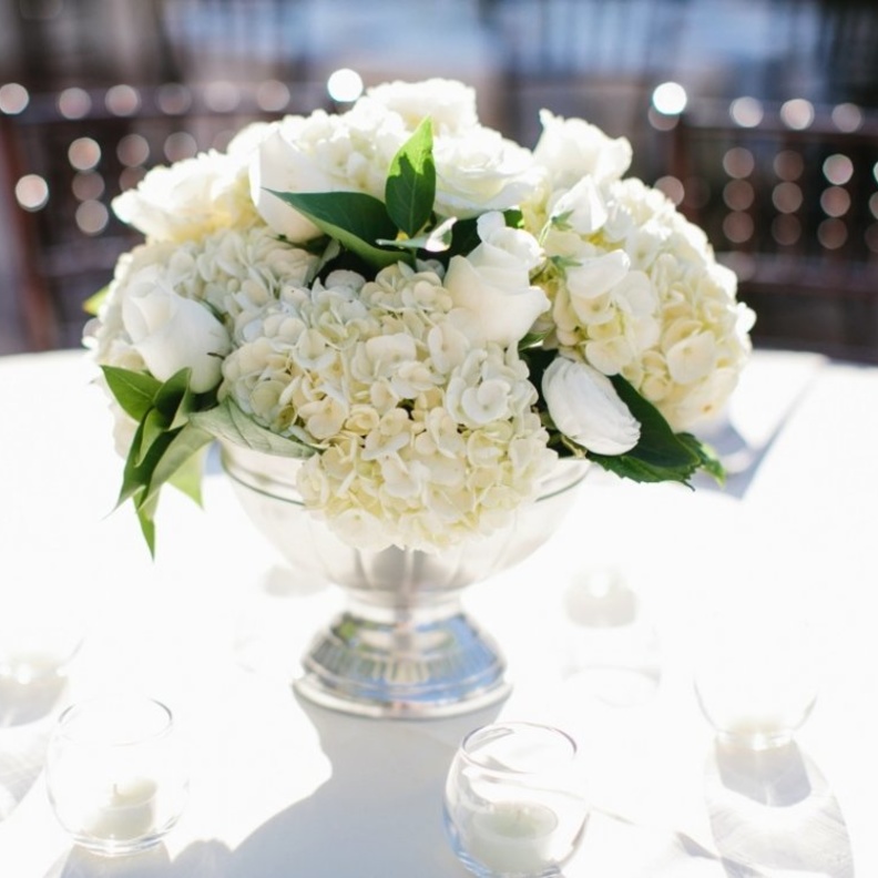 المزهريات المزينة بالورود البيضاء في حفل الزفاف